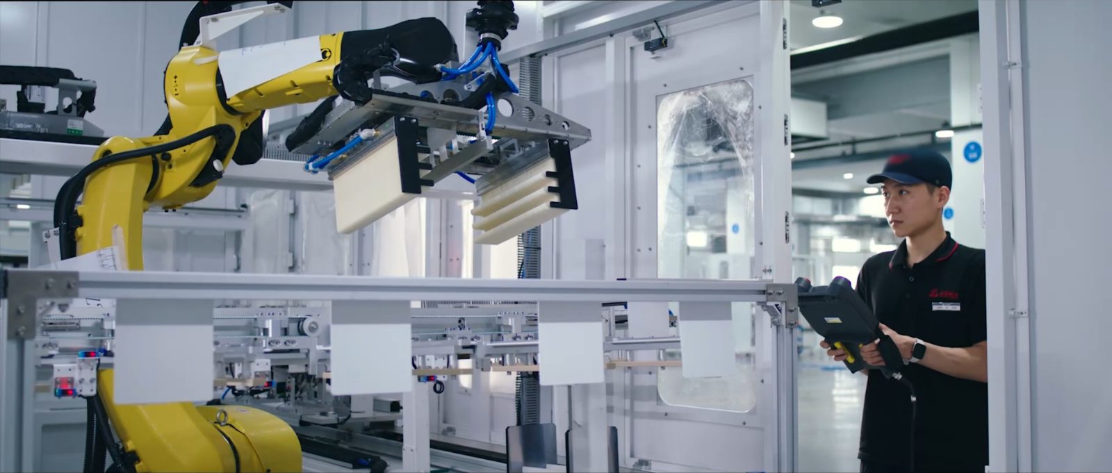 An engineer commissioning a robot arm in an automated assembly cell